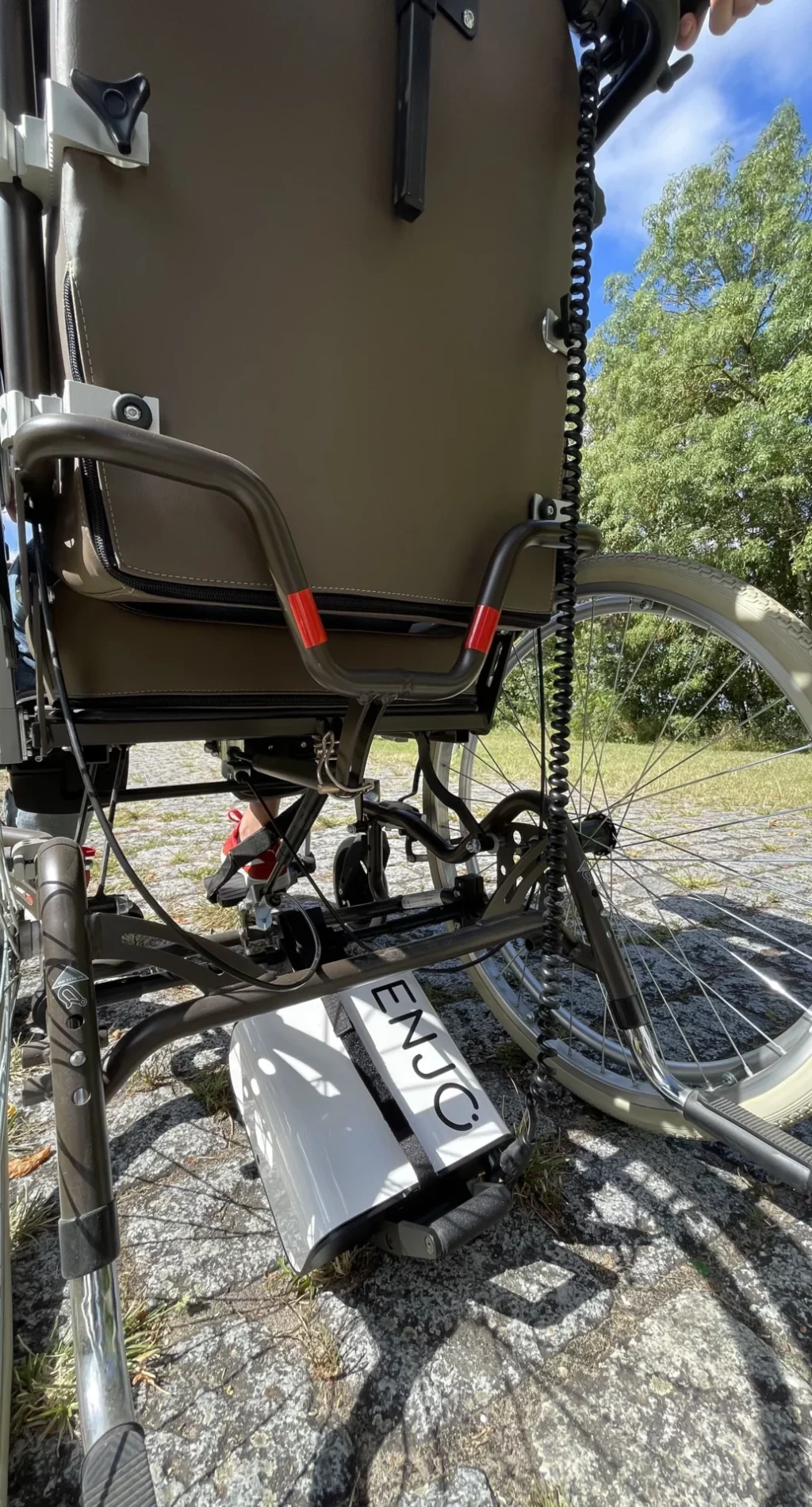 Aide à la poussée Enjo pour fauteuil roulant manuel lourd, permettant une motorisation facile.
